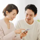 ご利用の流れページへのリンクを示すスマートフォンを見る男女の写真