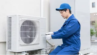ヒートポンプ室外機の設置工事をする作業スタッフ